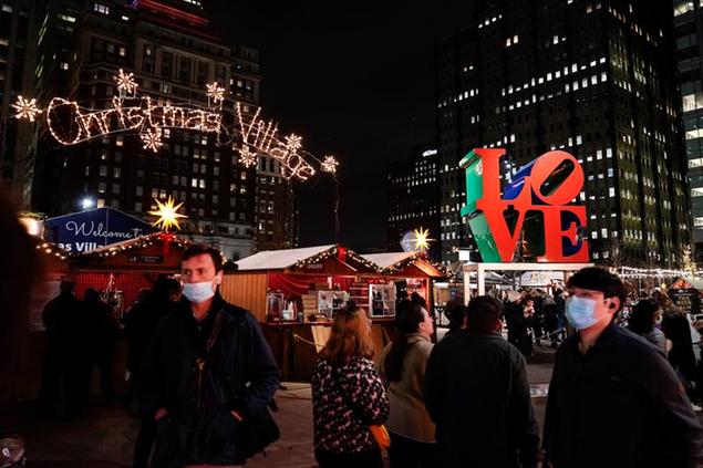 People wearing face masks to protect against the spread of the coronavirus visit the Christmas Village in Philadelphia, Wednesday, Dec. 15, 2021. (AP Photo/Matt Rourke)