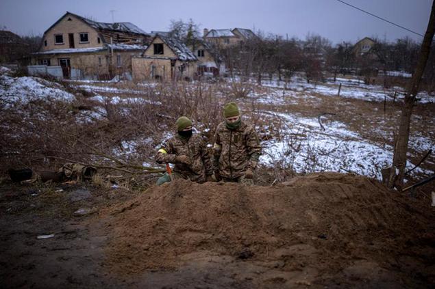 Ukrainian soldiers take positions in a trench on the outskirts of Kyiv, Ukraine, Wednesday, March 2, 2022. Russian forces have escalated their attacks on crowded cities in what Ukraine's leader called a blatant campaign of terror. (AP Photo/Emilio Morenatti)