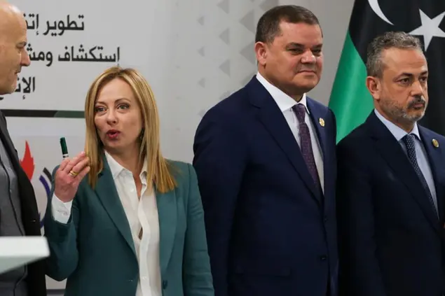 Italian Prime Minister Giorgia Meloni stands next to one of the Libya's rival prime ministers Abdul Hamid Dbeib, right, a during a conference in Tripoli, Libya, Saturday, Jan. 28, 20223. (AP Photo/Yousef Murad)