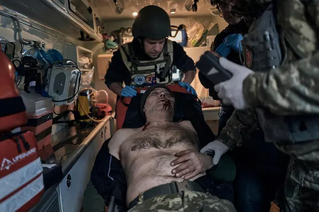 Military medics give first aid to a soldier wounded in a battle in an evacuation vehicle near Bakhmut, Donetsk region, Ukraine, Wednesday, Feb. 22, 2023. (AP Photo/Libkos)