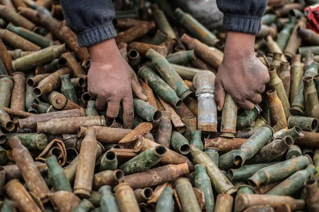 01 March 2021, Syria, Idlib: A child sorts through defective weaponry cartridges at a dump centre run by Junaid family for selling remnants of shellings and unexploded ordnances, to be recycled and used in useful industries. Some residents of Idlib province work in the threatening war-born business of collecting and trading remnants of artillery, cluster bombs, and other unexploded ordnances, to earn their living and cope with the dire consequences of the war. Photo by: Anas Alkharboutli/picture-alliance/dpa/AP Images