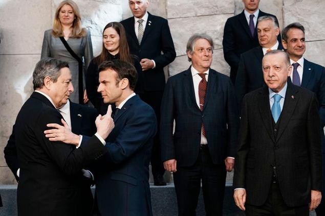 French President Emmanuel Macron, second left, speaks with Italian Prime Minister Mario Draghi, left, at a group photo during an extraordinary NATO summit at NATO headquarters in Brussels, Thursday, March 24, 2022. As the war in Ukraine grinds into a second month, President Joe Biden and Western allies are gathering to chart a path to ramp up pressure on Russian President Vladimir Putin while tending to the economic and security fallout that's spreading across Europe and the world. (AP Photo/Thibault Camus)