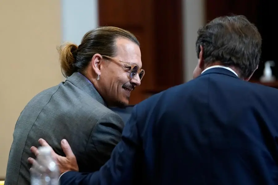 Attorney Ben Chew speaks to his client, actor Johnny Depp in the courtroom at the Fairfax County Circuit Court in Fairfax, Va., Wednesday May 4, 2022. Depp sued his ex-wife Amber Heard for libel in Fairfax County Circuit Court after she wrote an op-ed piece in The Washington Post in 2018 referring to herself as a \\\"public figure representing domestic abuse.\\\" (Elizabeth Frantz/Pool Photo via AP)