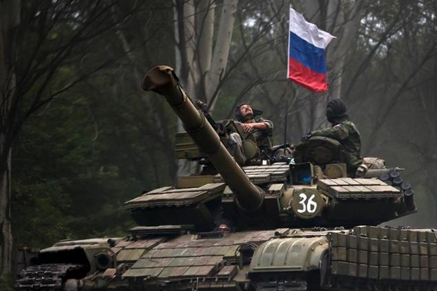 FILE - A pro-Russian rebel looks up while riding on a tank flying Russia's flag, on a road east of Donetsk, eastern Ukraine, July 29, 2015. Amid fears of a Russian invasion of Ukraine, tensions have also soared in the country\\u00E2\\u20AC\\u2122s east, where Ukrainian forces are locked in a nearly eight-year conflict with Russia-backed separatists. A sharp increase in skirmishes on Thursday raised fears that Moscow could use the situation as a pretext for an incursion. (AP Photo/Vadim Ghirda, File)
