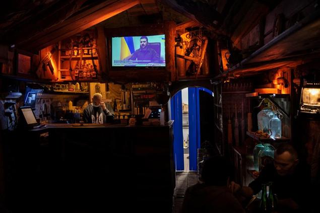 Ukrainian President Volodymyr Zelenskyy appears on the television inside a bar in downtown Lviv, western Ukraine, Tuesday, March 22, 2022. Ukrainian forces fought off continuing Russian efforts to occupy Mariupol and claimed to have retaken a strategic suburb of Kyiv on Tuesday, mounting a defense so dogged that it is stoking fears Russia's Vladimir Putin will escalate the war to new heights. (AP Photo/Bernat Armangue)