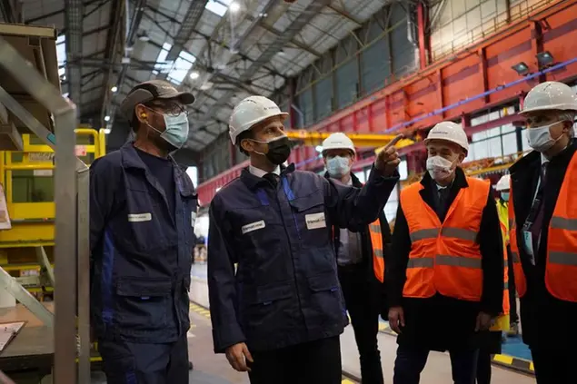 French President Emmanuel Macron, center, speaks with a woker as he visits Framatome, an international leader in nuclear energy, designing, manufacturing and installing fuel, instrumentation and control systems for nuclear power plants, in Le Creusot, central France, Tuesday, Dec. 8, 2020. (AP Photo/Laurent Cipriani, Pool)
