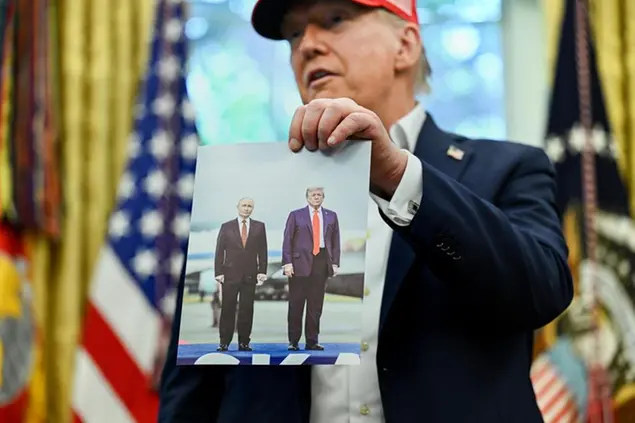 Donald Trump mostra la foto del suo ultimo incontro con Putin