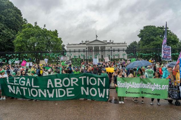 Abortion-rights protesters shout slogans after tying green flags to the fence of the White House during a protest to pressure on the Biden administration to act and protect abortion rights in Washington, Saturday, July 9, 2022. (AP Photo/Gemunu Amarasinghe)