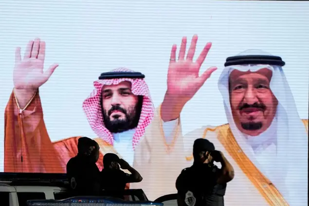 FILE - Saudi special forces salute in front of a screen displaying images Saudi King Salman, right, and Crown Prince Mohammed bin Salman after a military parade in preparation for the annual Hajj pilgrimage, in the Muslim holy city of Mecca, Saudi Arabia, July 3, 2022. President Joe Biden\\u00E2\\u20AC\\u2122s visit to the Middle East this week includes meeting with Saudi Arabia's King Salman and crown prince Mohammed bin Salman, the de facto leader of the oil-rich kingdom who U.S. intelligence officials determined\\u00C2\\u00A0approved the killing\\u00C2\\u00A0of a U.S.-based journalist Jamal\\u00C2\\u00A0Khashoggi.\\u00C2\\u00A0(AP Photo/Amr Nabil, File)