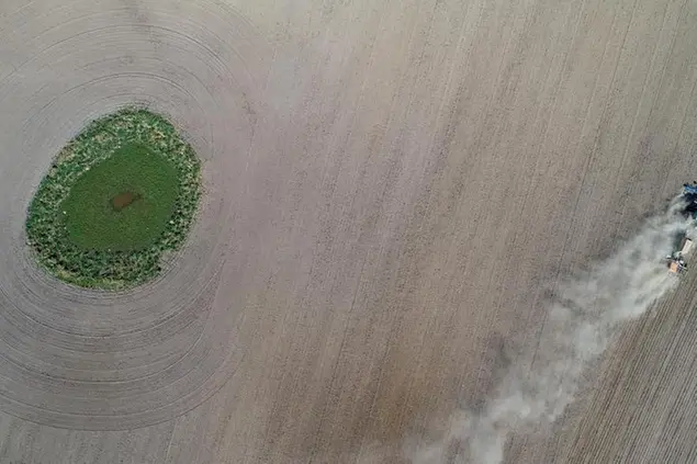 18 April 2020, Brandenburg, Jacobsdorf: An employee of the Beckmann agricultural company drills maize into the dry soil and kicks up a lot of dust (aerial photo with a drone). Photo by: Patrick Pleul/picture-alliance/dpa/AP Images