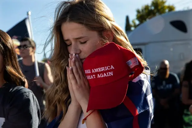 Liza Durasenko, 16, from Oregon City, Ore., prays during a rally in support of President Donald Trump, Aug. 29, 2020, in Clackamas, Ore. (AP Photo/Paula Bronstein)