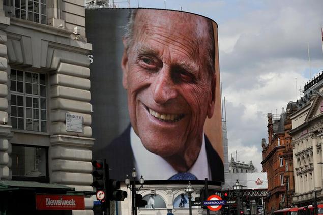 A tribute to Britain's Prince Philip is projected onto a large screen at Piccadilly Circus in London, Friday, April 9, 2021. Buckingham Palace officials say Prince Philip, the husband of Queen Elizabeth II, has died. He was 99. Philip spent a month in hospital earlier this year before being released on March 16 to return to Windsor Castle. (AP Photo/Matt Dunham)