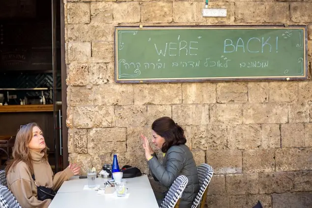 (Un bar di Tel Aviv riapre i battenti. \\\"We're back\\\". Foto AP)