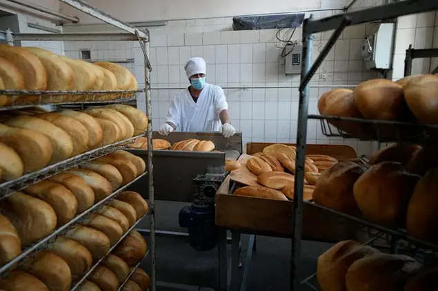 Un dipendente sovrintende alla cottura del pane secondo le ricette dell'èra sovietica a Skadovsk, regione di Kherson, Ucraina meridionale (Foto AP)