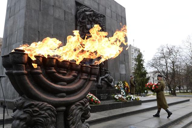 A wreath is laid at the monument to the Heroes of the Warsaw Ghetto in Warsaw, Poland, on Wednesday, Jan. 27, 2021, as part of world observances of the 76th anniversary of the liberation of the Nazi German death camp Auschwitz. Some 1.1 million people, mostly Jewish, were killed during World War II. Most observances were held online, due to the coronavirus pandemic, and only few people attended the ceremony at the monument.(AP Photo/Czarek Sokolowski)
