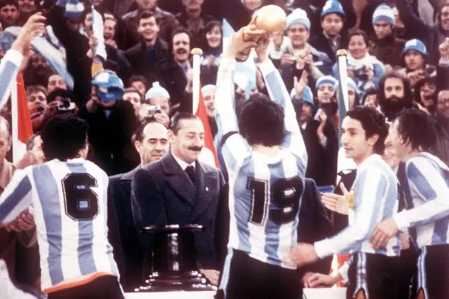 Argentine President Jorge Rafael Videla (centre) after he had presented the World Cup Trophy to Argentine's captain Daniel Passarella (No 19), at the presentation ceremony in the River Plate Stadium, Buenos Aires, June 25, 1978. Other players from left Americo Gallego (6), Passarella, Osvaldo Ardilles and unknown. Argentina beat Holland 3-1 in the final. (AP PHOTO/stf/Ducklau)