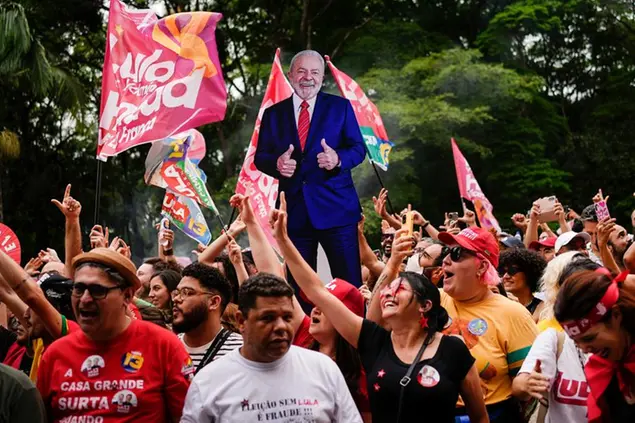 Supporters cheer during a campaign rally for former President Luiz Inacio Lula da Silva, pictured in a life-size cutout in the background, in Sao Paulo, Brazil, Saturday, Oct. 29, 2022. On Sunday, Brazilians head to the voting booth again to choose between da Silva and incumbent Jair Bolsonaro, who are facing each other in a runoff vote after neither got enough support to win outright in the Oct. 2 general election.(AP Photo/Matias Delacroix)