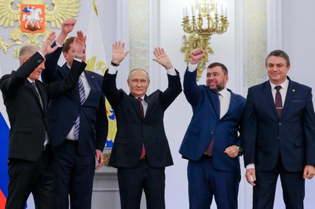 From left, Moscow-appointed head of Kherson Region Vladimir Saldo, Moscow-appointed head of Zaporizhzhia region Yevgeny Balitsky, Russian President Vladimir Putin, center, Denis Pushilin, the leader of the Donetsk People's Republic and Leonid Pasechnik, leader of self-proclaimed Luhansk People's Republic wave during a ceremony to sign the treaties for four regions of Ukraine to join Russia, at the Kremlin in Moscow, Friday, Sept. 30, 2022. The signing of the treaties making the four regions part of Russia follows the completion of the Kremlin-orchestrated \\\"referendums.\\\" (Mikhail Metzel, Sputnik, Kremlin Pool Photo via AP)
