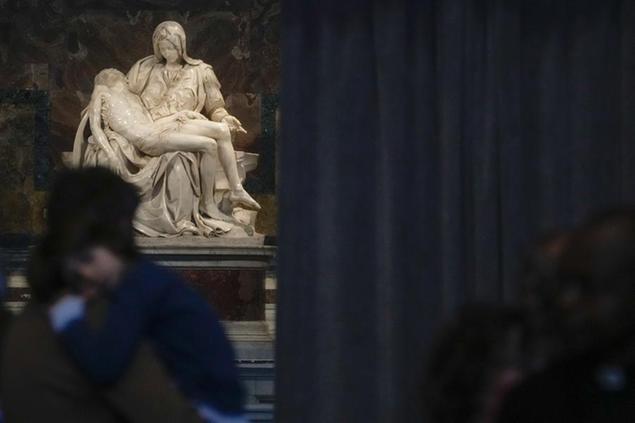 Faithful walk past Michelangelo's Pieta' at the end of a mass celebrated by Pope Francis on the occasion of the World Day of the Poor in St. Peter's Basilica, at the Vatican, Sunday, Nov. 13, 2022. (AP Photo/Gregorio Borgia)