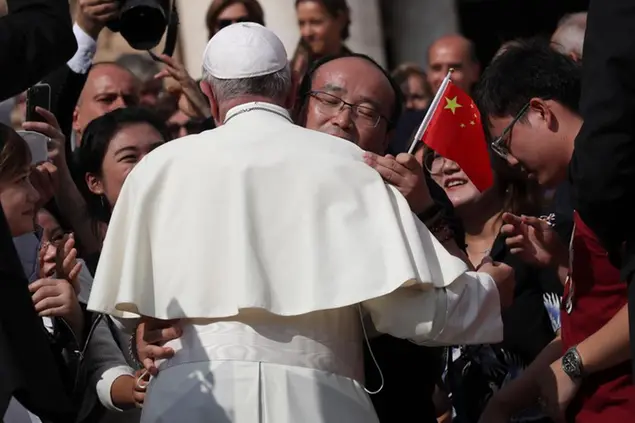 Pope Francis is hugged by Chinese faithful coming from the Tuscany city of Prato, at the end of his weekly general audience in St. Peter's Square at the Vatican, Wednesday, Oct. 2, 2019. (AP Photo/Alessandra Tarantino)