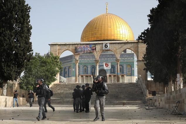 Israeli security forces take positions during clashes with Palestinians in front of the Dome of the Rock Mosque at the Al Aqsa Mosque compound in Jerusalem's Old City Monday, May 10, 2021. Israeli police clashed with Palestinian protesters at a flashpoint Jerusalem holy site on Monday, the latest in a series of confrontations that is pushing the contested city to the brink of eruption. Palestinian medics said at least 180 Palestinians were hurt in the violence at the Al-Aqsa Mosque compound, including 80 who were hospitalized. (AP Photo/Mahmoud Illean)