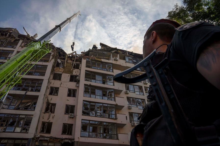 Servicemen work at the scene at a residential building following explosions, in Kyiv, Ukraine, Sunday, June 26, 2022. Several explosions rocked the west of the Ukrainian capital in the early hours of Sunday morning, with at least two residential buildings struck, according to Kyiv mayor Vitali Klitschko. (AP Photo/Nariman El-Mofty)