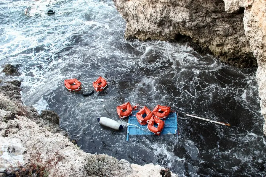 Debris and life jackets from capsized boat float by the rocky shore of the Sicilian island of Lampedusa, southern Italy, Sunday, Nov. 24, 2019. Italian news reports say the Italian coast guard has recovered seven bodies of migrants near Lampedusa and kept up its search Sunday of rough seas for as many as 13 other migrants feared missing after their boat capsized on Saturday. (AP Photo/Mauro Seminara)