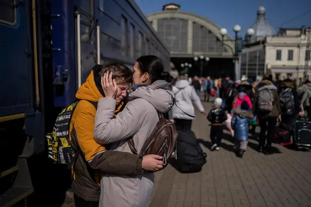 Una madre riabbraccia il figlio fuggito dall'assedio di Mariupol al suo arrivo alla stazione di Lviv (Ap)